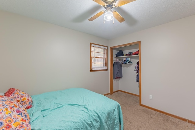 carpeted bedroom featuring a closet, ceiling fan, and a textured ceiling