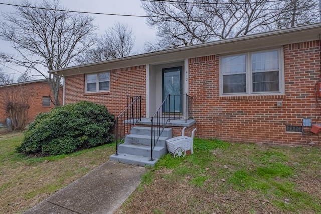 view of exterior entry with a yard