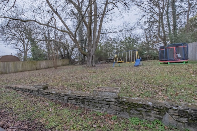 view of yard featuring a playground and a trampoline