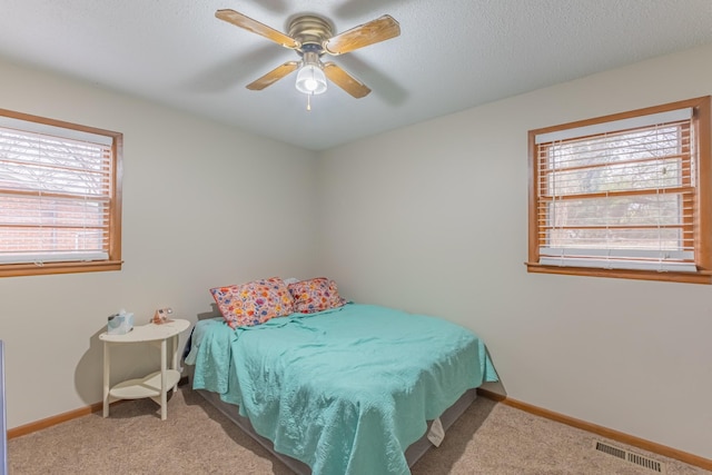 bedroom with light carpet, multiple windows, and ceiling fan