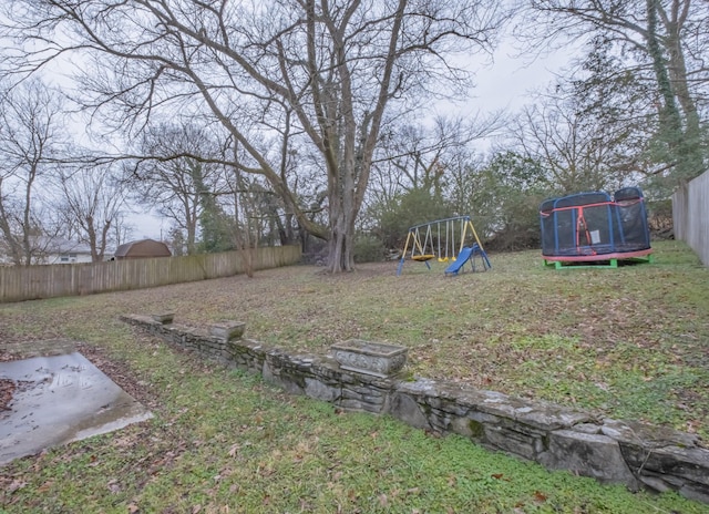 view of yard featuring a playground and a trampoline