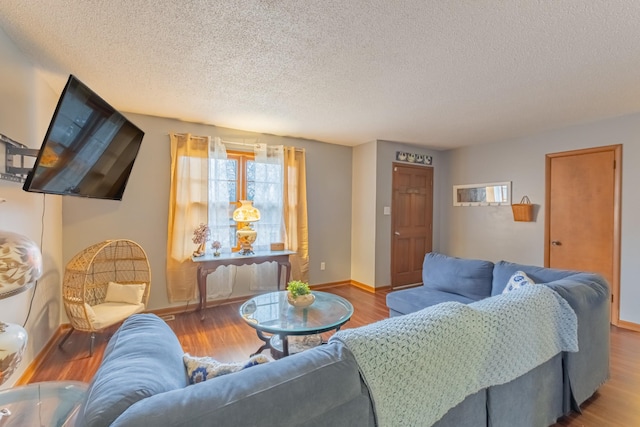 living room with wood-type flooring and a textured ceiling