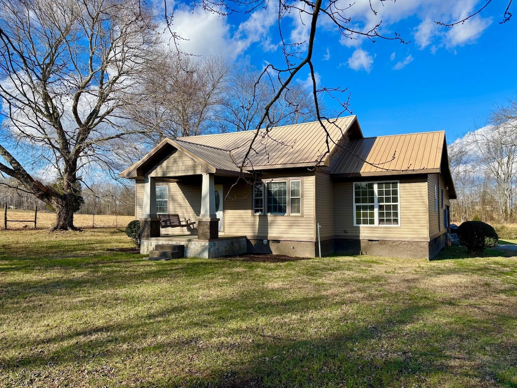 rear view of house featuring a yard