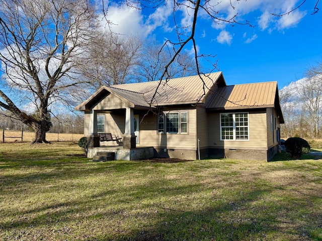 rear view of house featuring a yard