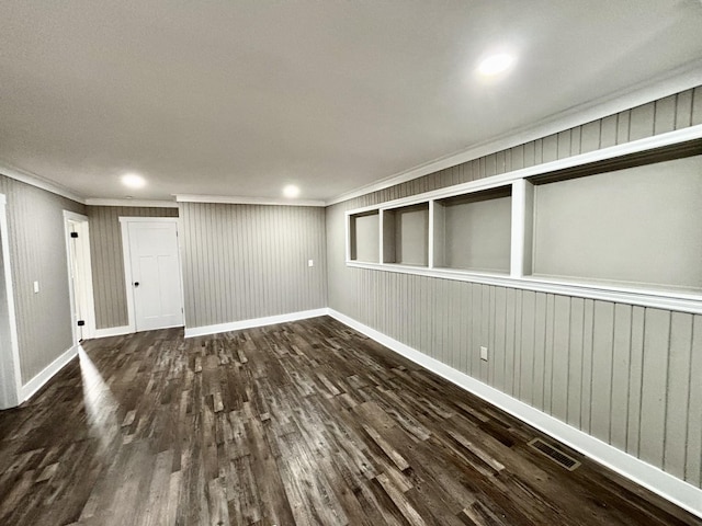 unfurnished room with ornamental molding and dark wood-type flooring