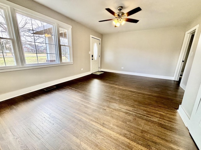 empty room with dark hardwood / wood-style floors and ceiling fan