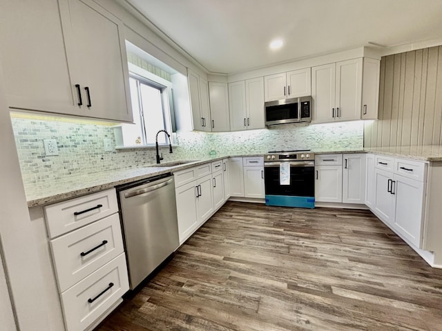 kitchen featuring white cabinetry, stainless steel appliances, tasteful backsplash, and sink