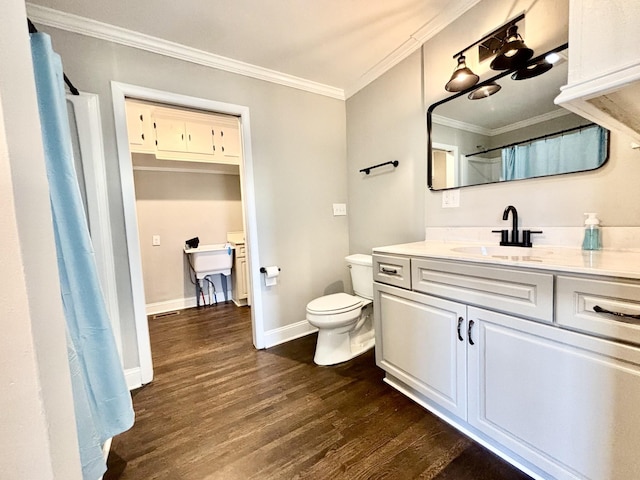 bathroom featuring ornamental molding, vanity, toilet, and wood-type flooring