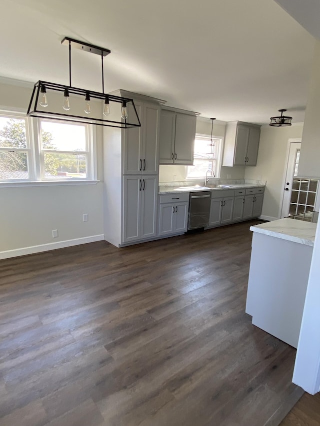 kitchen with stainless steel dishwasher, decorative light fixtures, gray cabinetry, a healthy amount of sunlight, and dark hardwood / wood-style floors