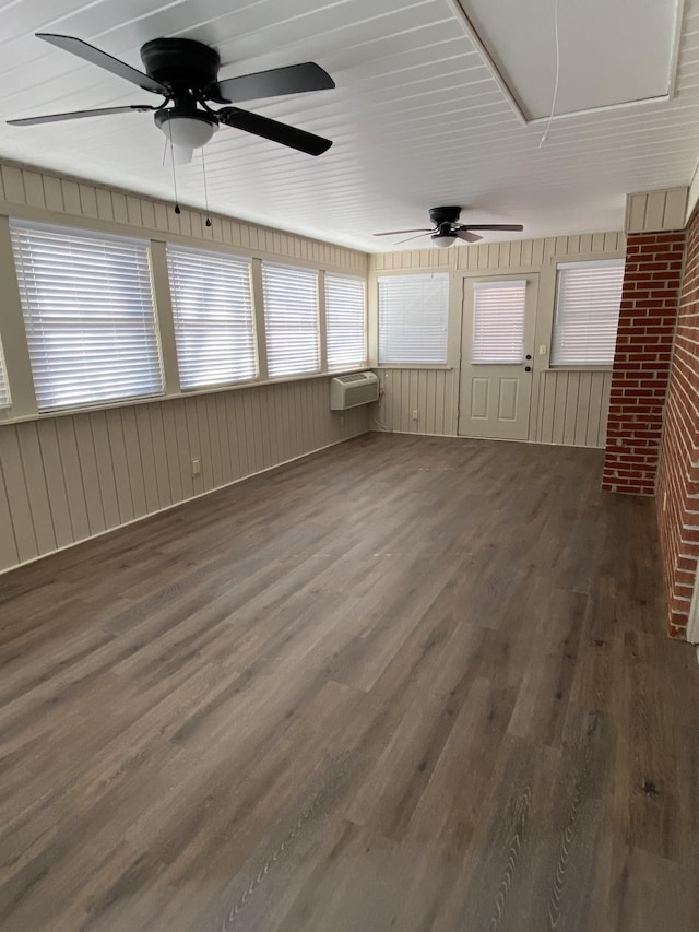 unfurnished sunroom featuring a wall mounted air conditioner and ceiling fan