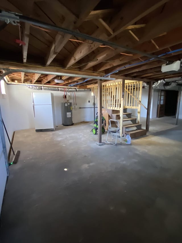 basement featuring white refrigerator and electric water heater