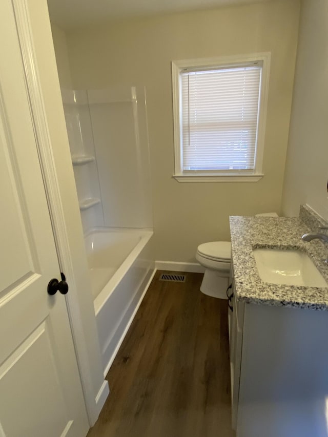 full bathroom featuring hardwood / wood-style flooring, toilet, shower / tub combination, and vanity