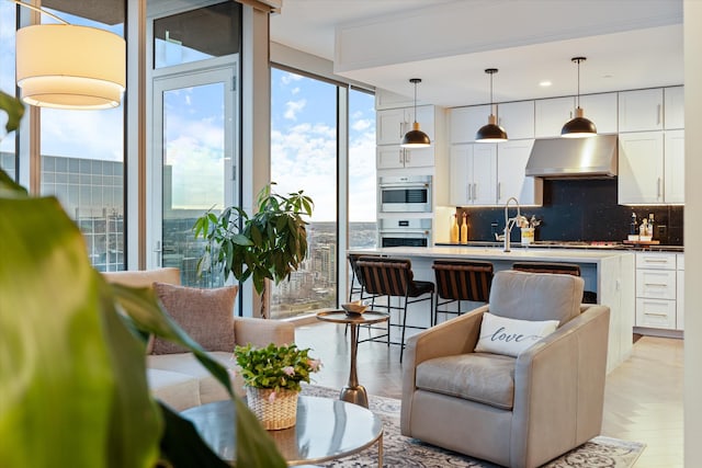 living room with light parquet flooring and a wall of windows