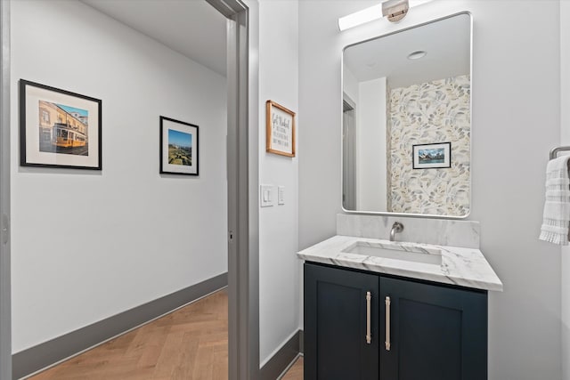 bathroom featuring parquet flooring and vanity