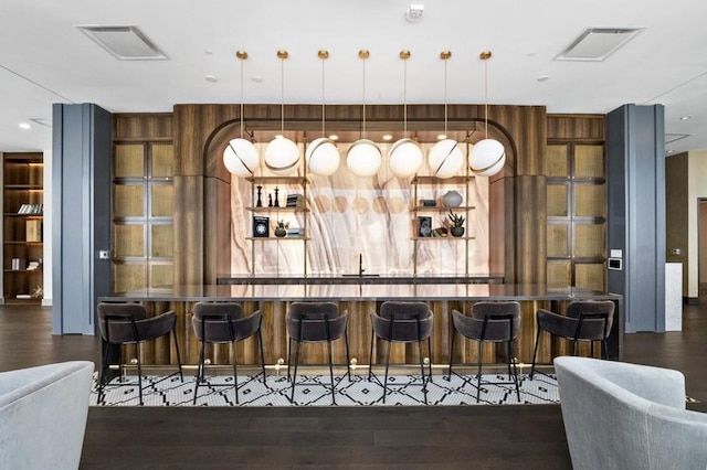 bar featuring decorative light fixtures and dark hardwood / wood-style floors