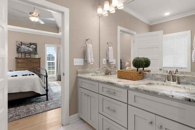 bathroom with vanity, hardwood / wood-style flooring, ceiling fan with notable chandelier, and ornamental molding