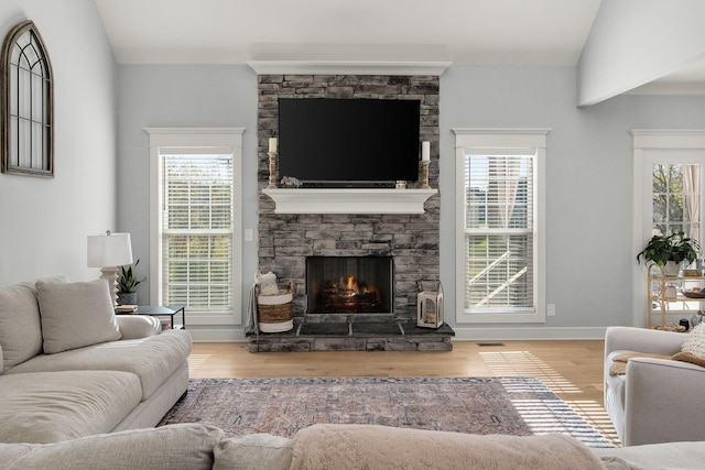 living room featuring hardwood / wood-style flooring, lofted ceiling, and a fireplace