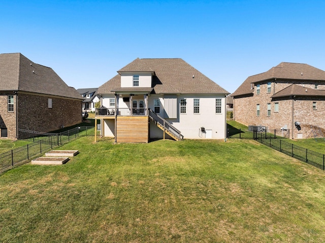 rear view of property with a lawn and a deck