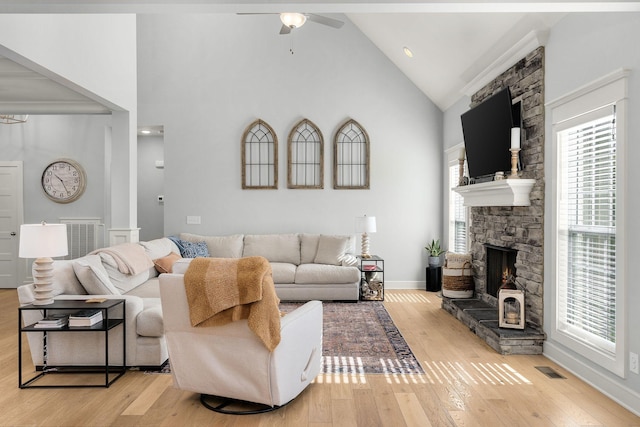 living room with ceiling fan, high vaulted ceiling, light hardwood / wood-style floors, and a fireplace