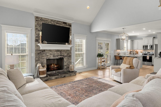 living room with a fireplace, light hardwood / wood-style floors, sink, and a healthy amount of sunlight