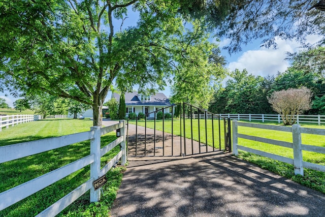 view of gate featuring a yard and a rural view