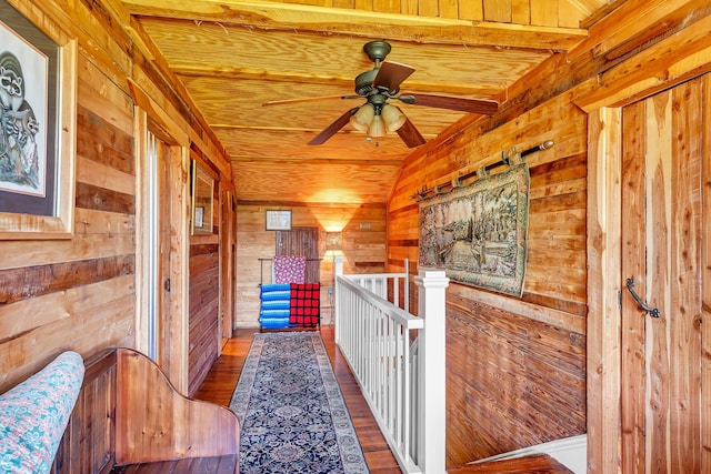 hallway with dark hardwood / wood-style floors, beamed ceiling, wood walls, and wood ceiling