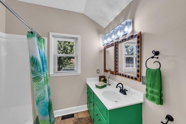 bathroom with shower / bath combo with shower curtain, a textured ceiling, tile patterned floors, vanity, and vaulted ceiling