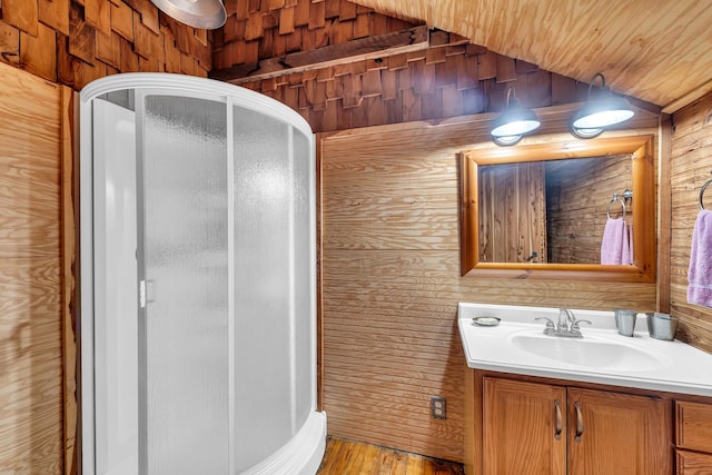 bathroom with hardwood / wood-style flooring, vanity, and wood walls