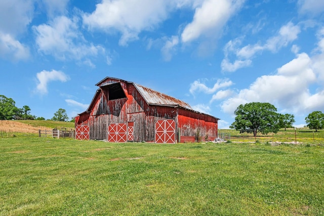 view of outdoor structure with a lawn and a rural view