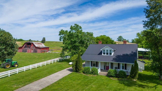 view of front of home featuring a front yard, an outbuilding, a porch, and a rural view