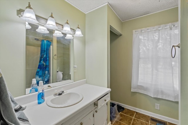 bathroom with crown molding, a textured ceiling, tile patterned floors, and vanity