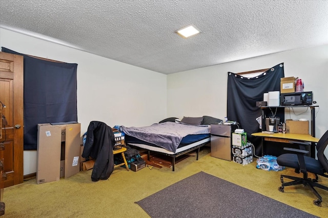 carpeted bedroom with a textured ceiling and stainless steel fridge