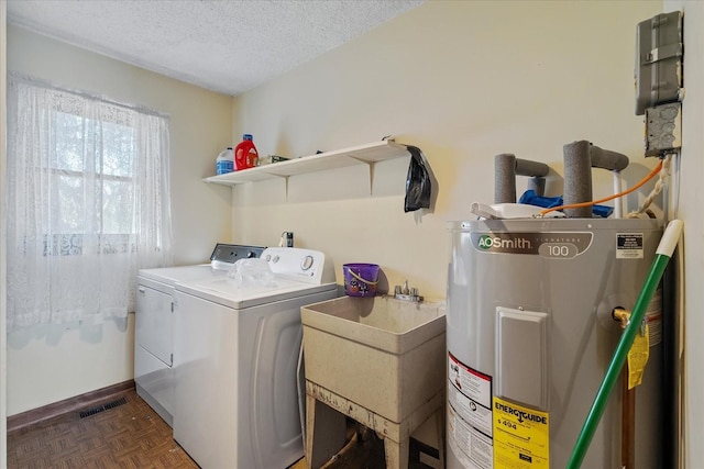 washroom with a textured ceiling, water heater, sink, dark parquet floors, and independent washer and dryer