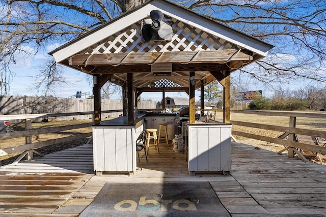 wooden deck featuring a gazebo and an outdoor bar