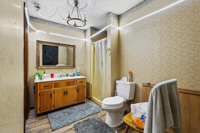 bathroom featuring a textured ceiling, toilet, vanity, and a shower with curtain