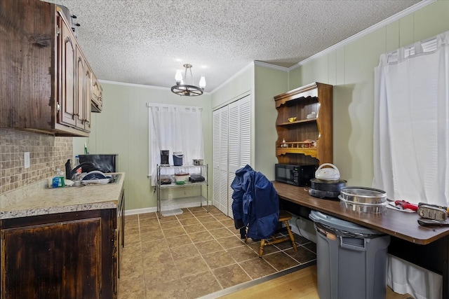 kitchen featuring a breakfast bar, crown molding, dark brown cabinets, and a chandelier