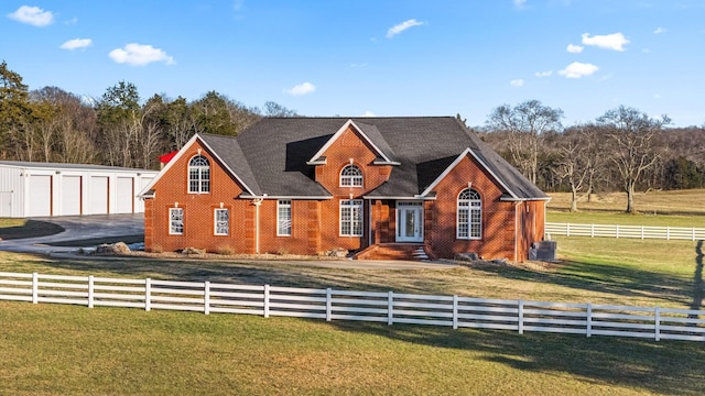 view of front facade featuring a front yard, a garage, and a rural view