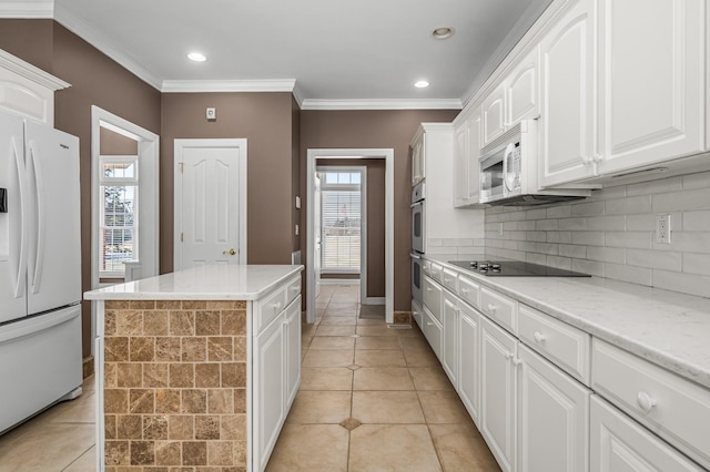 kitchen featuring a kitchen island, white cabinetry, white appliances, and light tile patterned floors