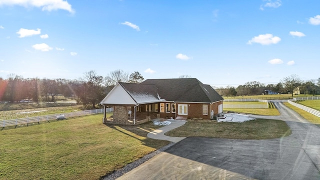 view of front of house with a front lawn and a rural view