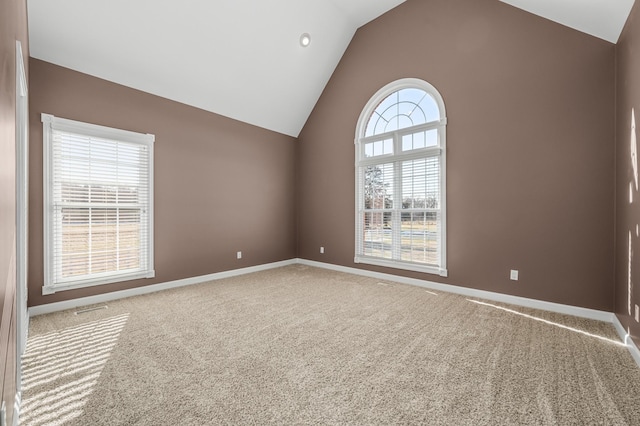 empty room featuring vaulted ceiling and carpet floors