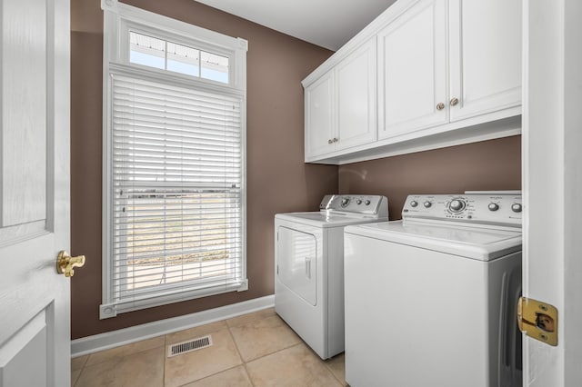 laundry area featuring cabinets, separate washer and dryer, and light tile patterned flooring