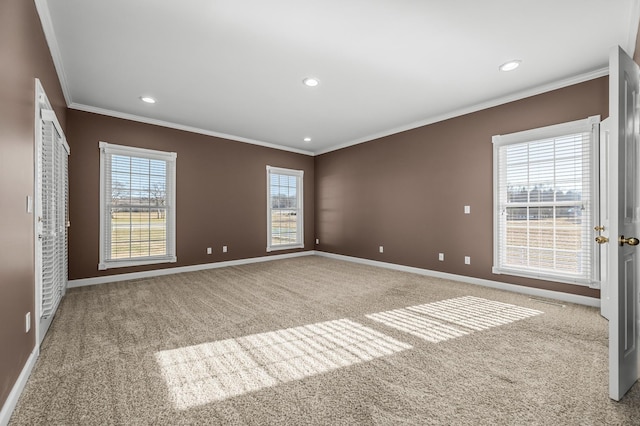 empty room featuring a wealth of natural light, ornamental molding, and carpet floors