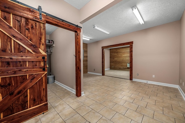 interior space with a textured ceiling and a barn door