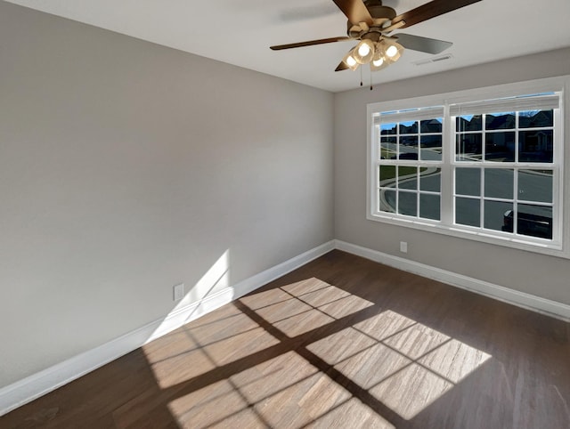 empty room with ceiling fan and dark wood-type flooring