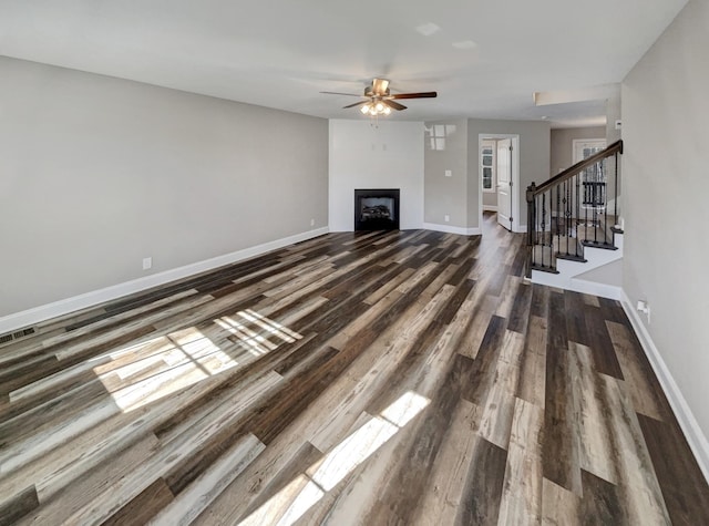 unfurnished living room with ceiling fan and dark hardwood / wood-style floors