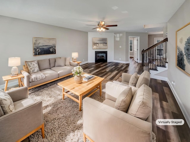 living room featuring dark wood-type flooring and ceiling fan