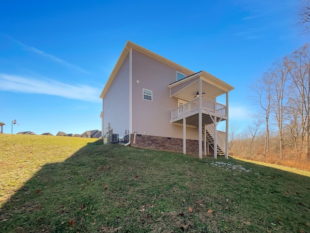 back of property with ceiling fan, a lawn, and central AC