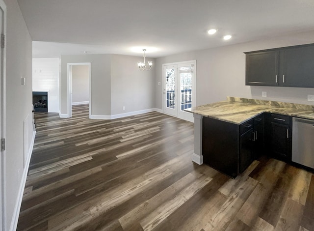 kitchen featuring pendant lighting, dishwasher, dark wood-type flooring, an inviting chandelier, and kitchen peninsula