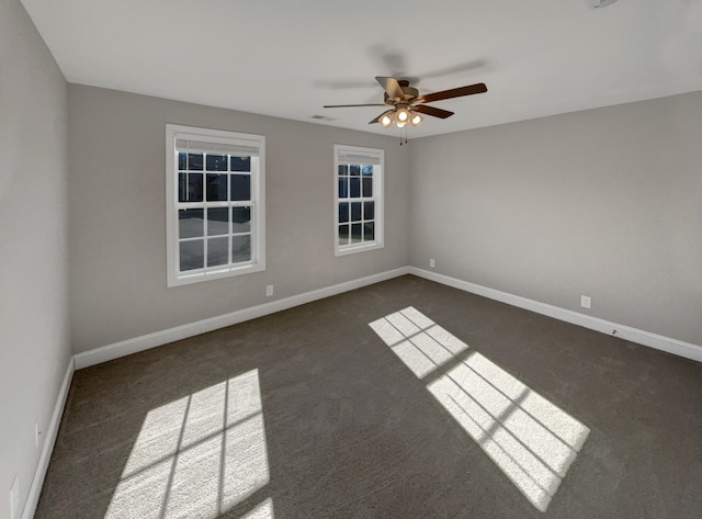 empty room featuring ceiling fan and dark carpet