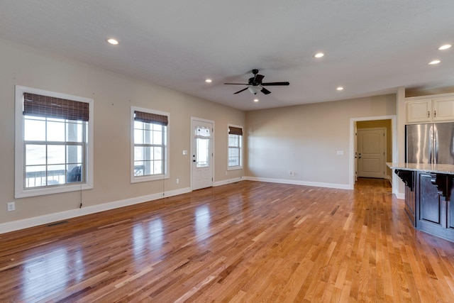 unfurnished living room with ceiling fan and light hardwood / wood-style floors